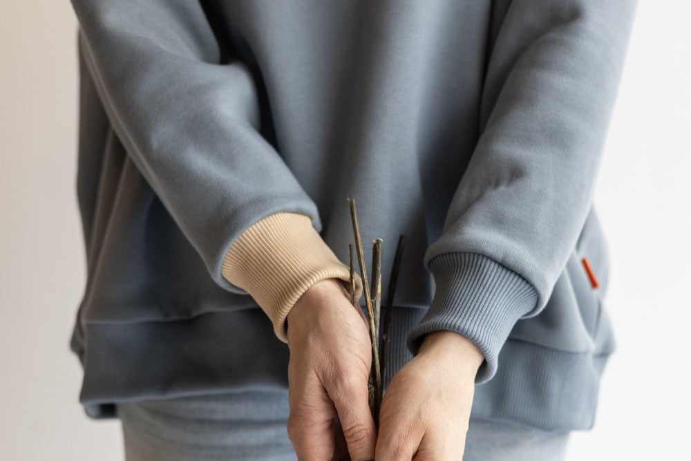 Close up view of an aesthete-(kids)wear organic cotton sweatshirt weared by a woman.