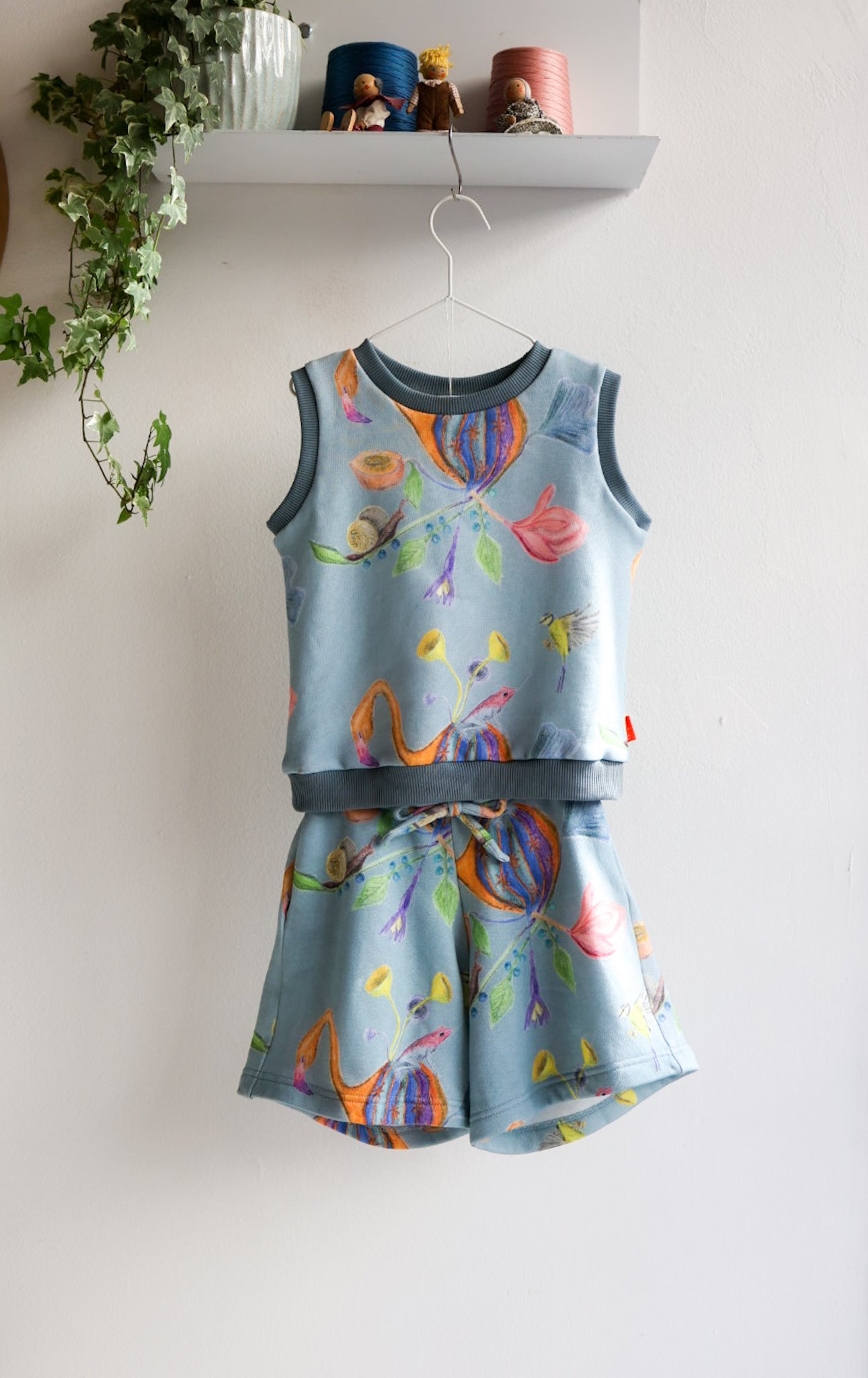 Children's sleeveless top and shorts set with colorful designs on a white background.