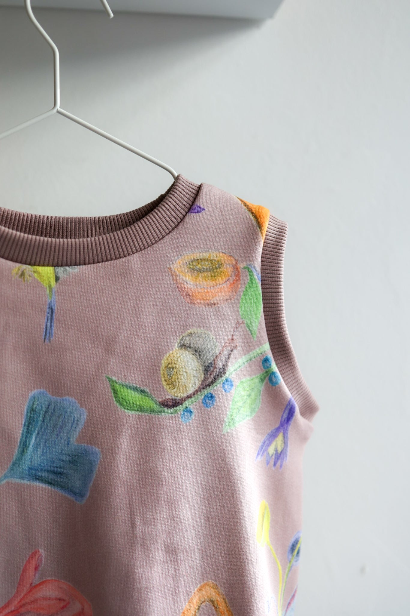 Children's sleeveless top with colorful floral pattern on a white background