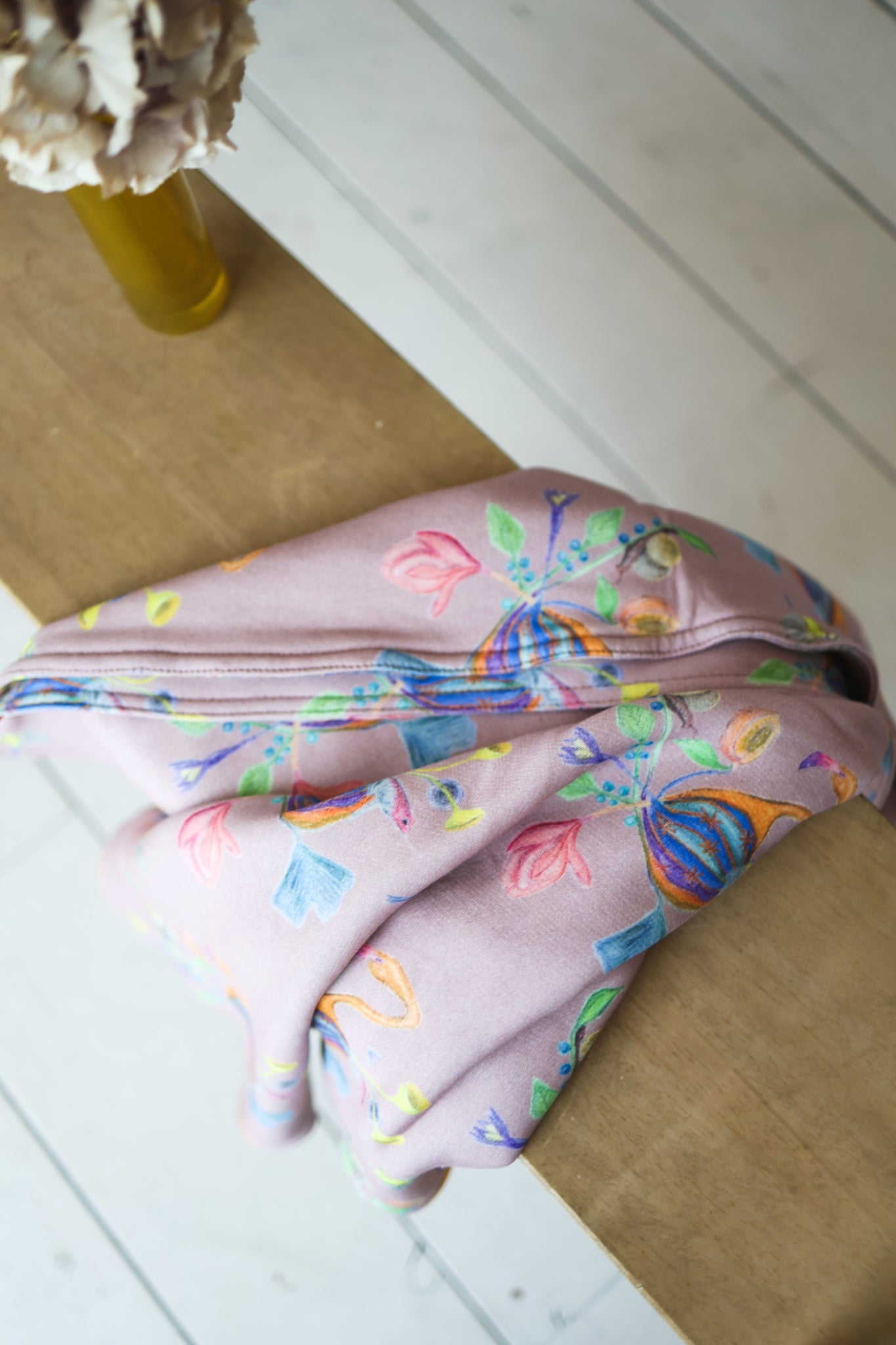 Colorful patterned babies blanket on a wooden floor.