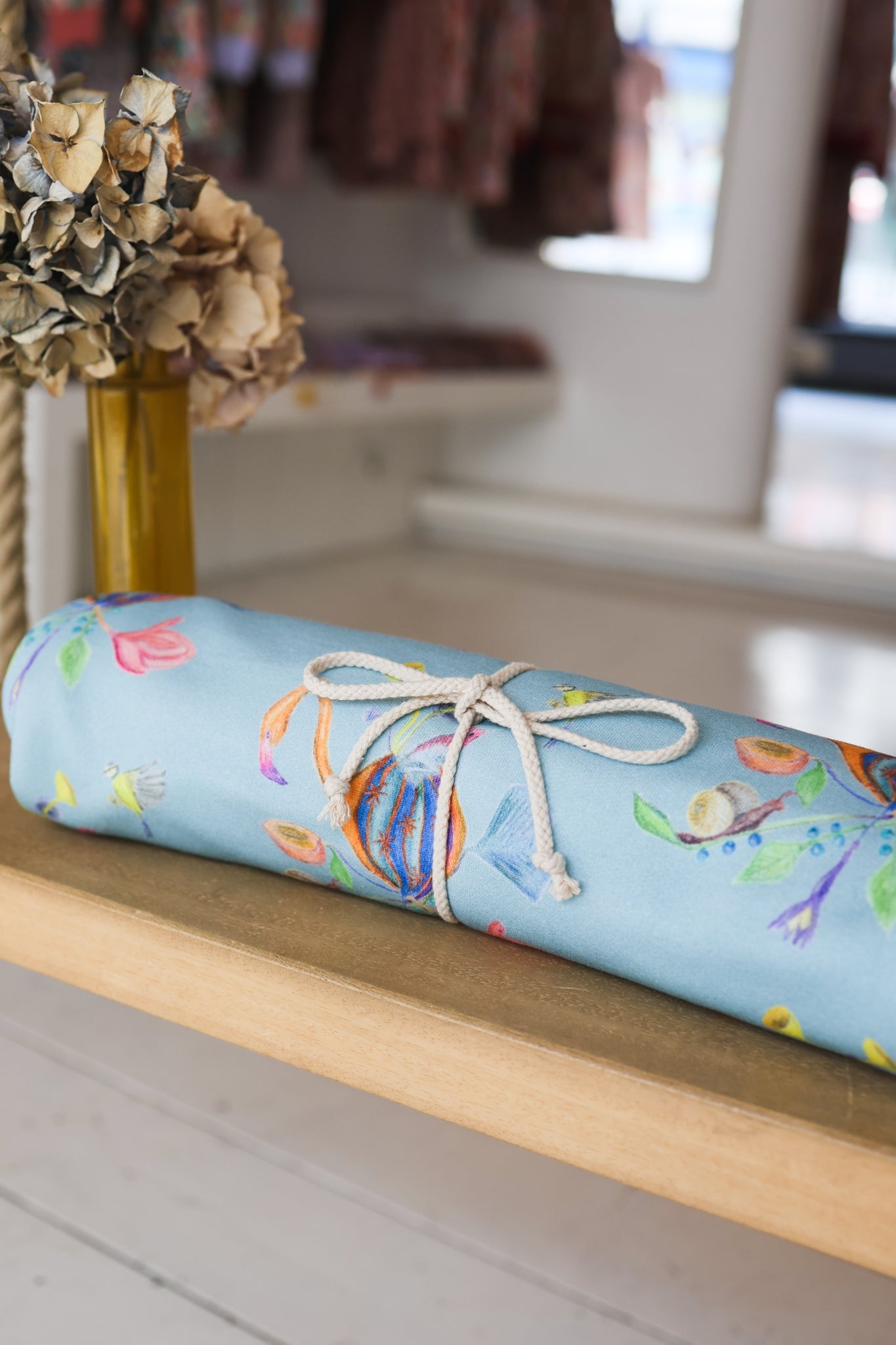 Roll of colorful babies blanket on a wooden surface.