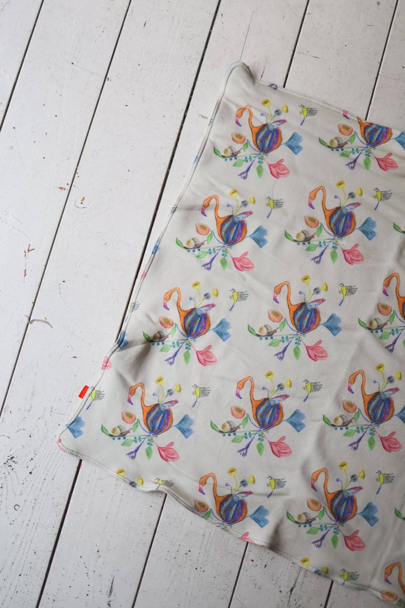 Patterned babies blanket on a wooden surface.