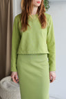 Woman wearing a green outfit with a plain background