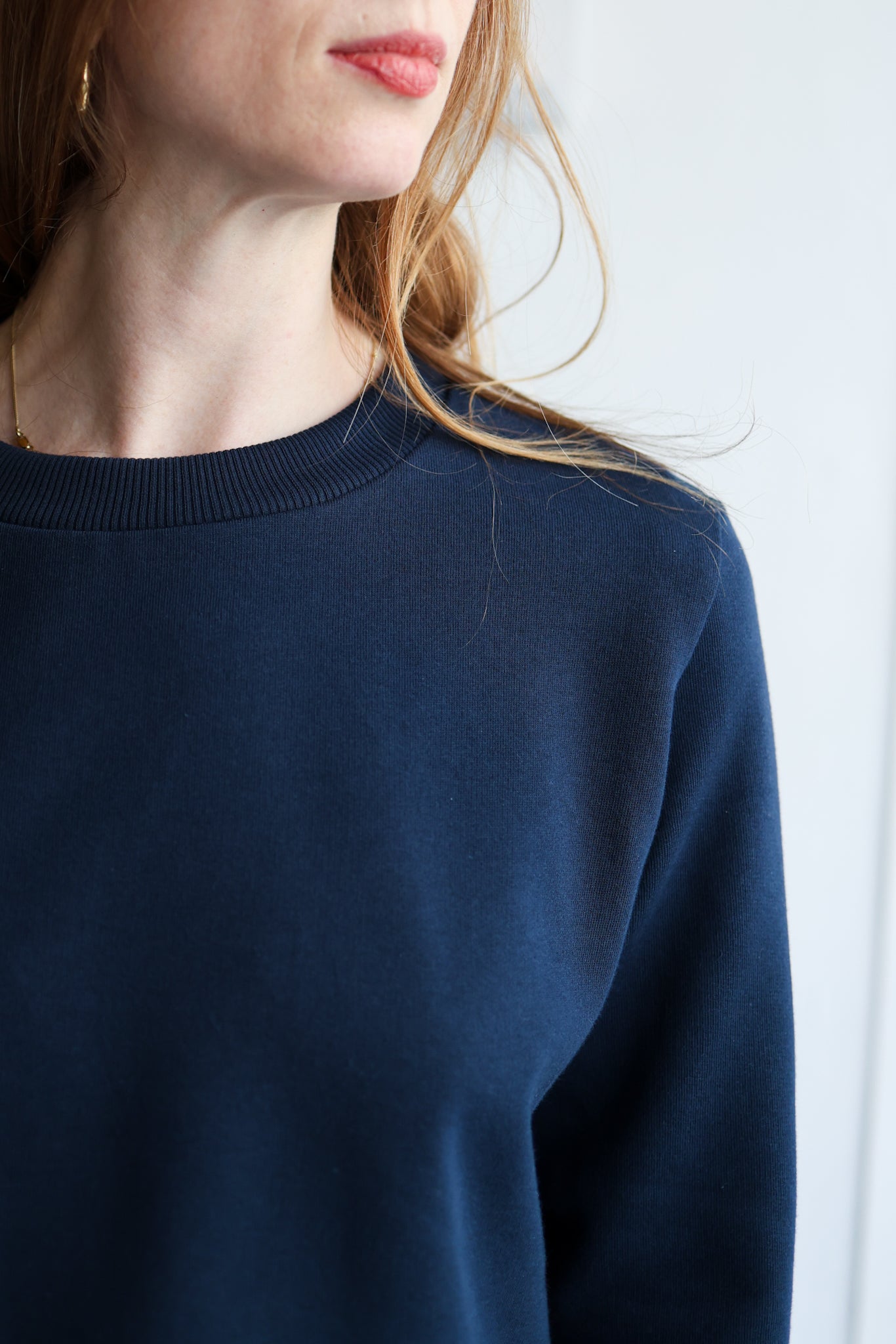 Navy blue sweater worn by a person against a white background