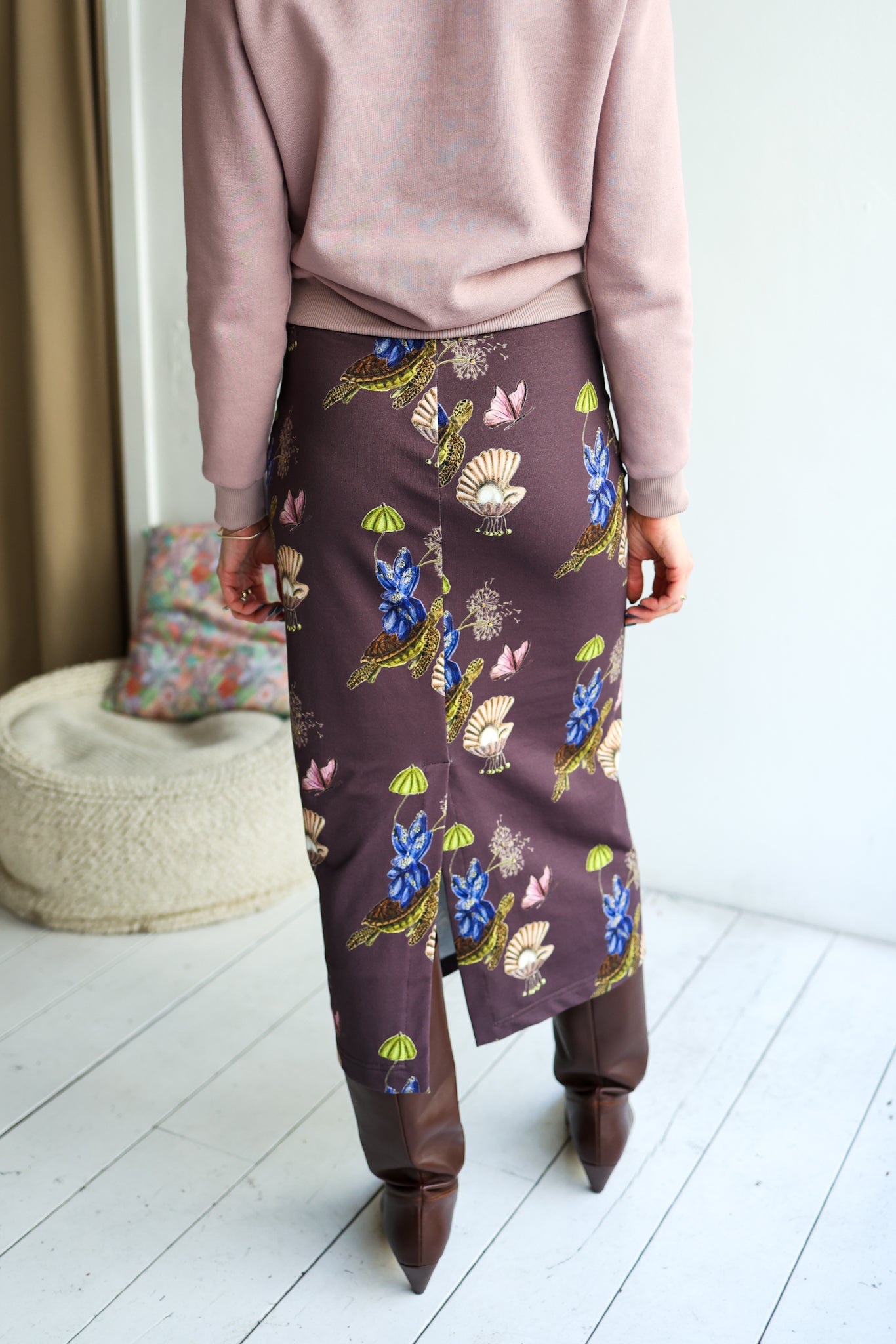 Person wearing a patterned skirt with a neutral background