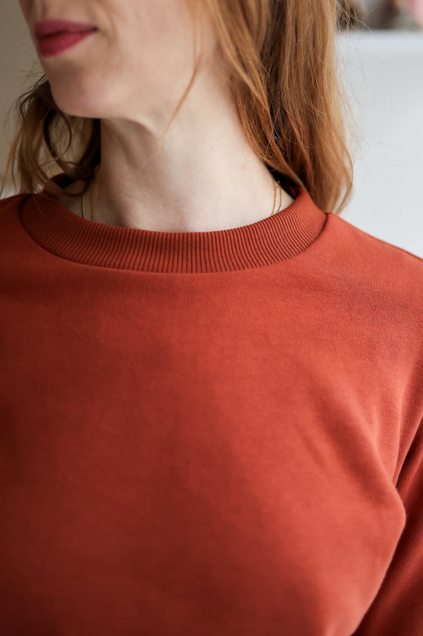 Close-up of a person wearing a rust-colored sweater